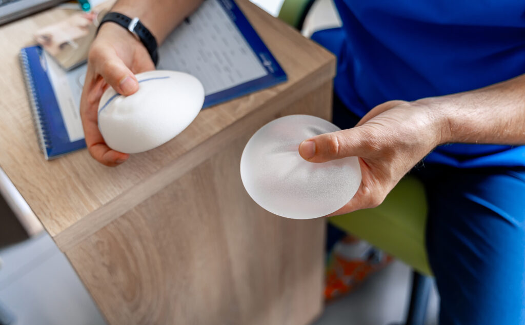 Plastic surgeon holding different size breast implants