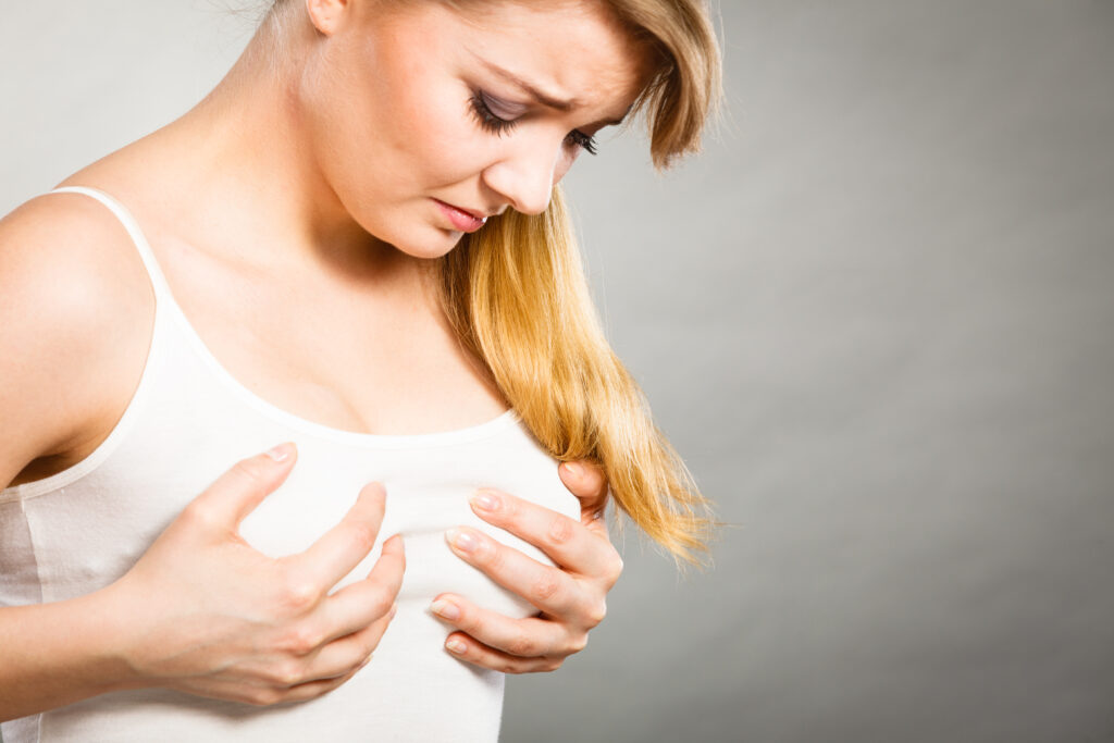 Woman holding her breasts as she considers breast implant placement