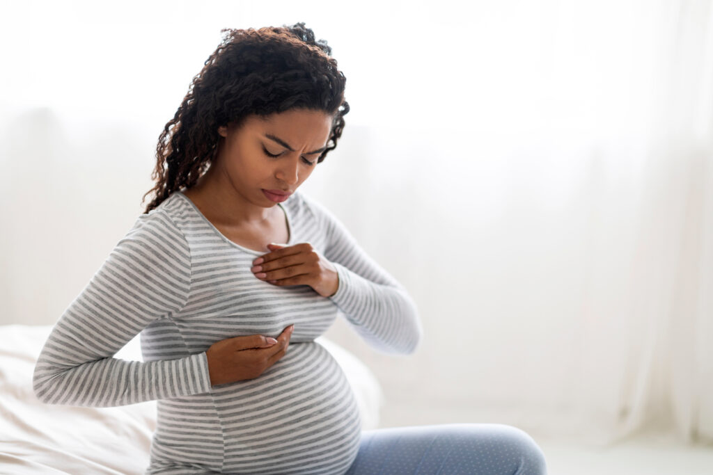 Image of a pregnant woman feeling her breast